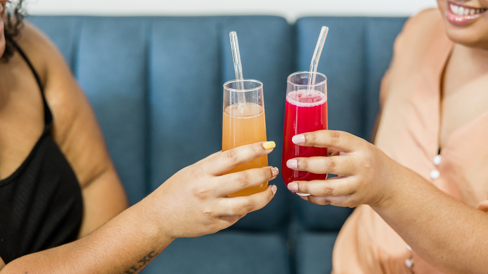 Two Black Women on a couch making a non-alcohlic toast